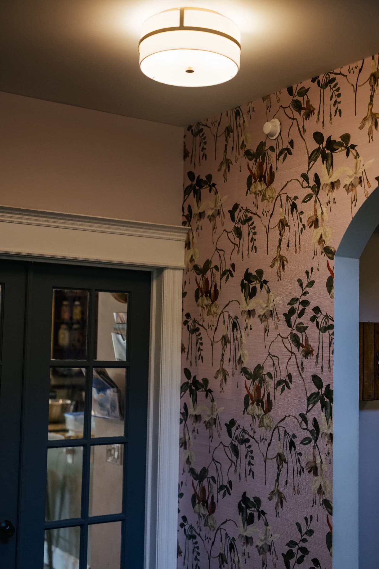 Floral wallpapered hallway with an arched doorway