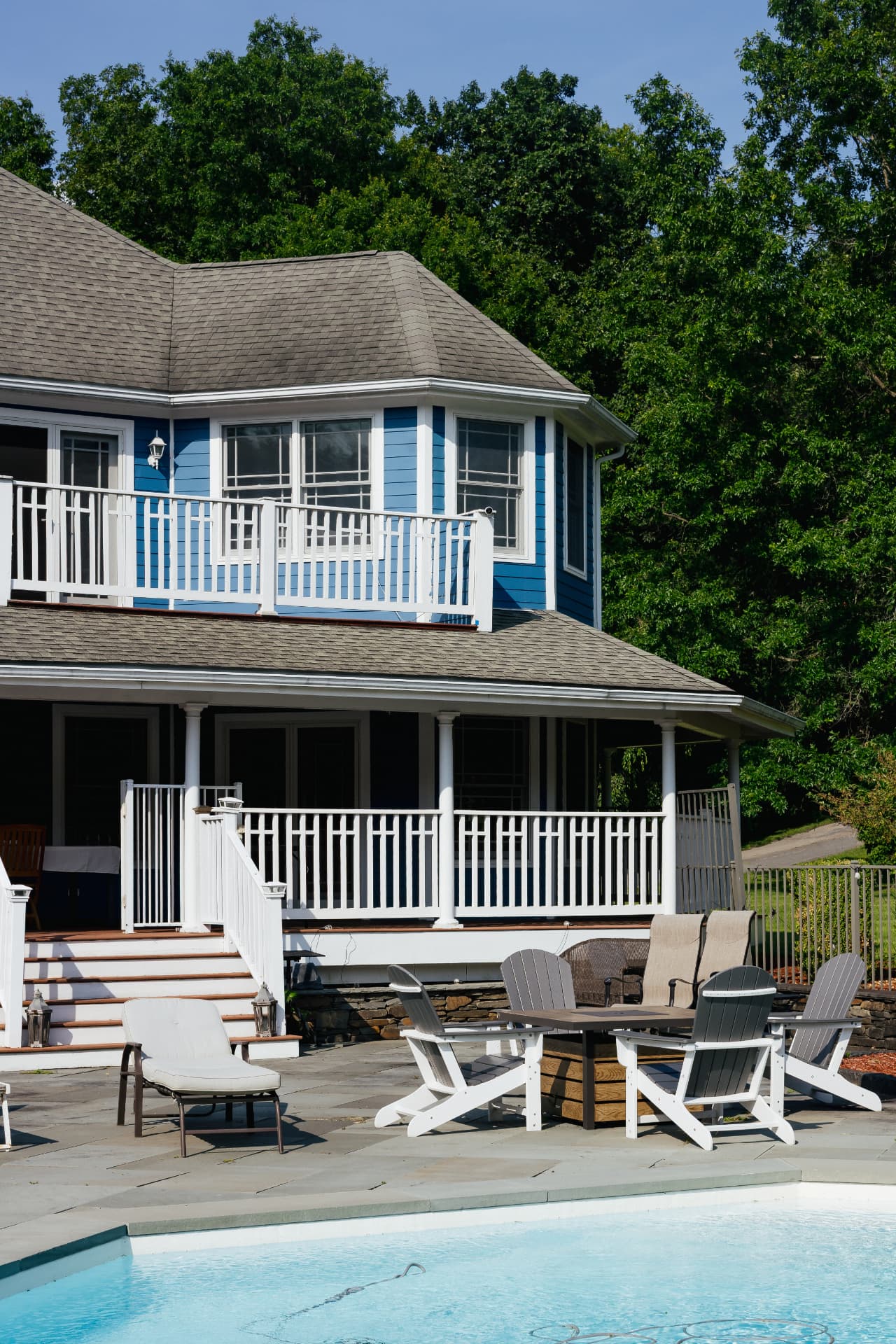 Adirondack chairs and a fire table on the bluestone pool patio