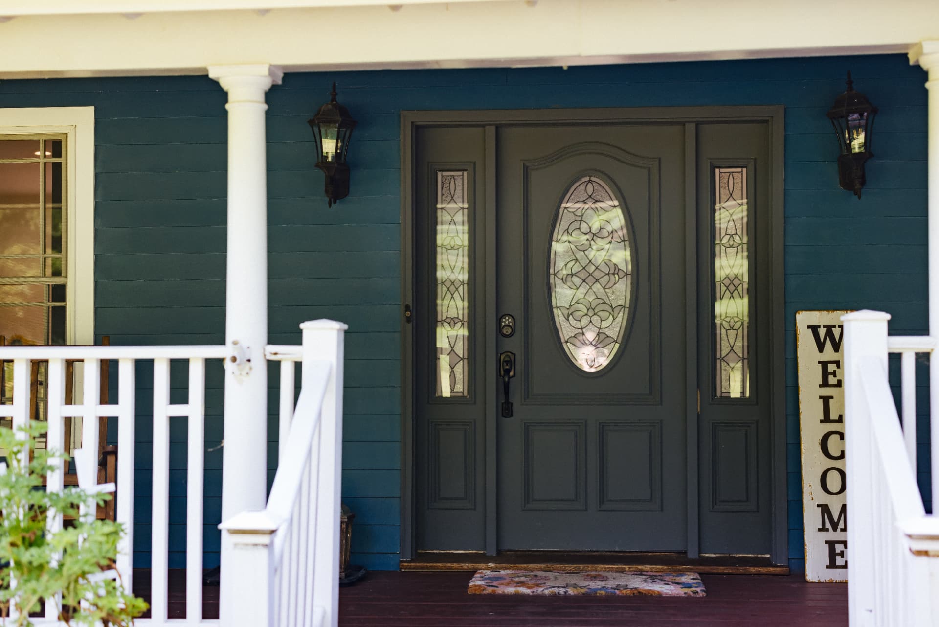 Front door with leaded glass and a welcome sign on the porch