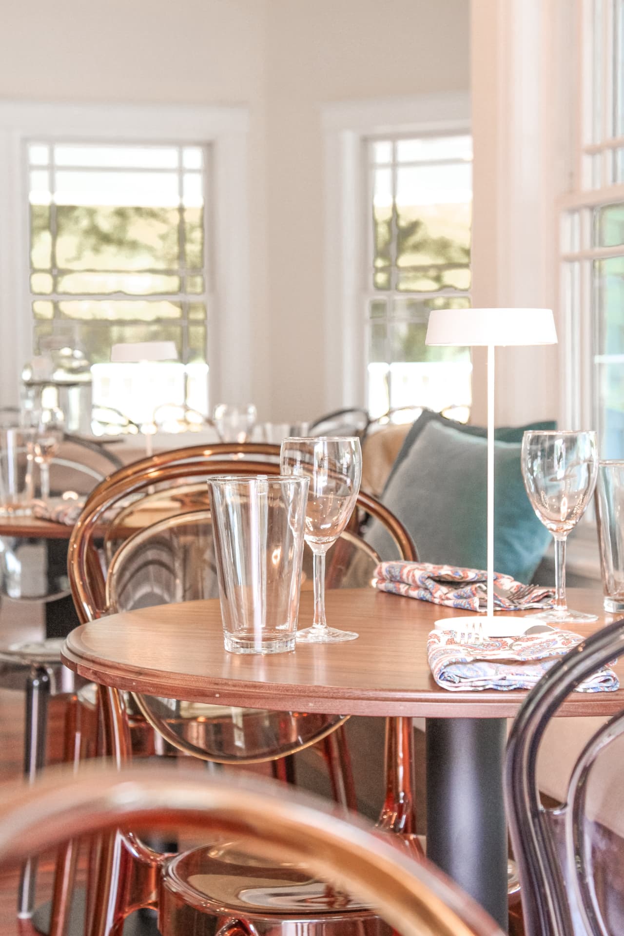 Table set with glassware beside tall windows