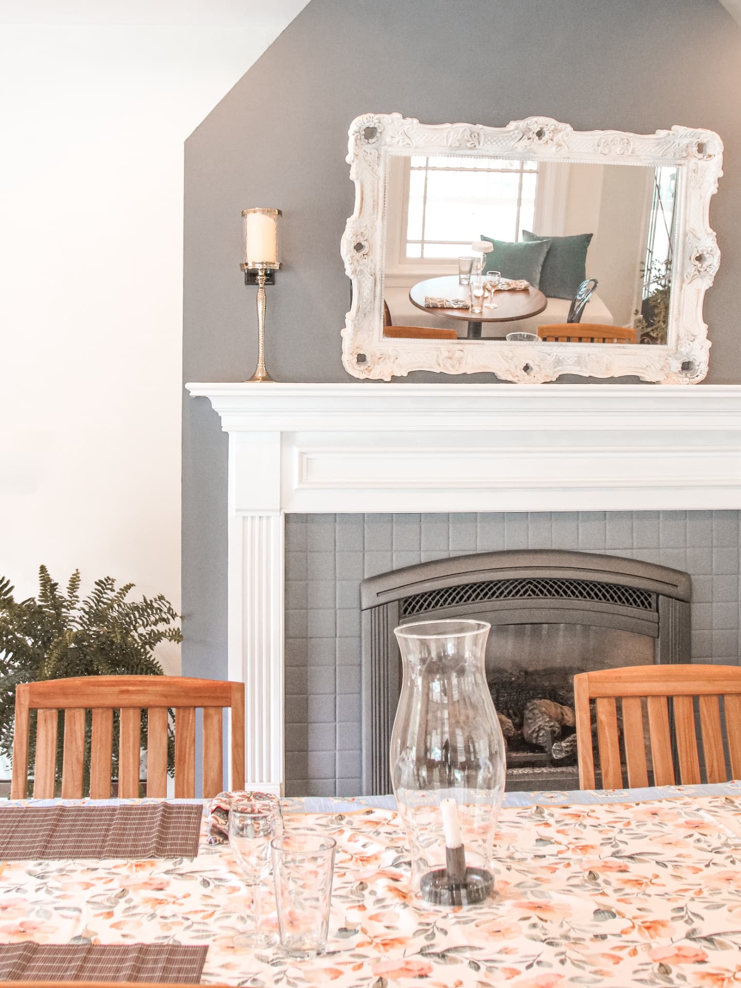 Fireplace with a white mantel and antique mirror in the dining room