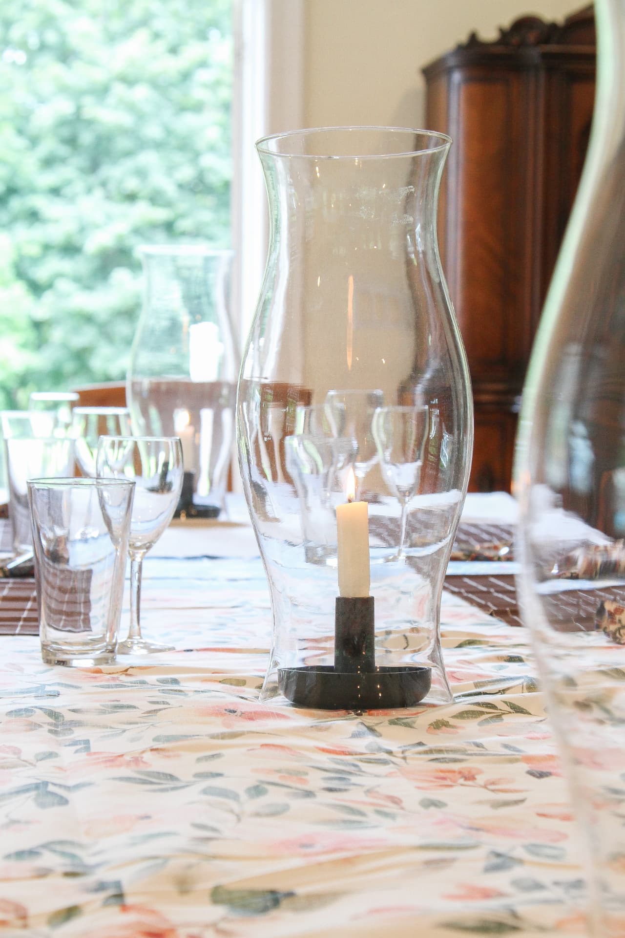 Candlelight and a floral linen on a set dinner table