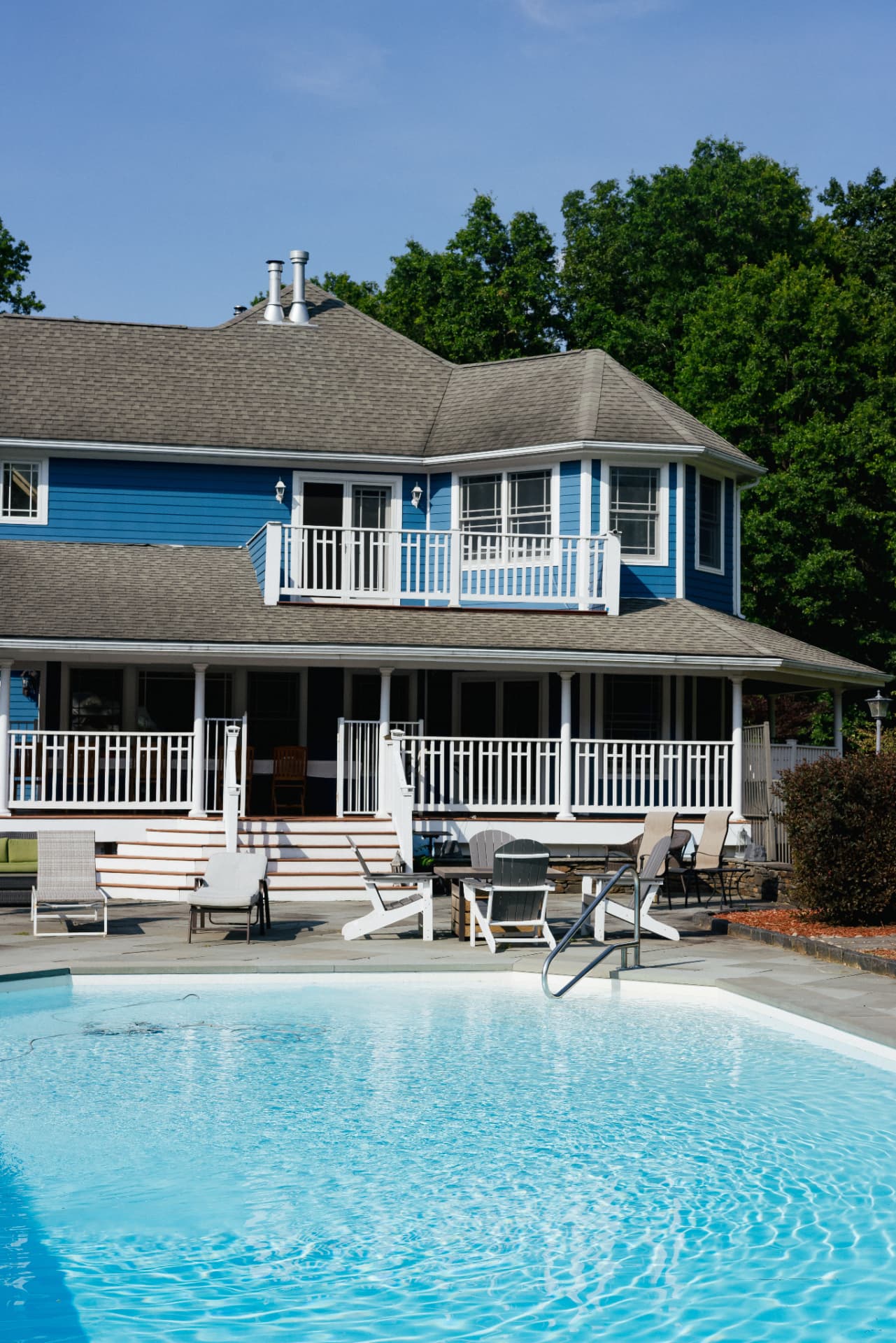 Pool deck with lounge chairs and the covered porch behind