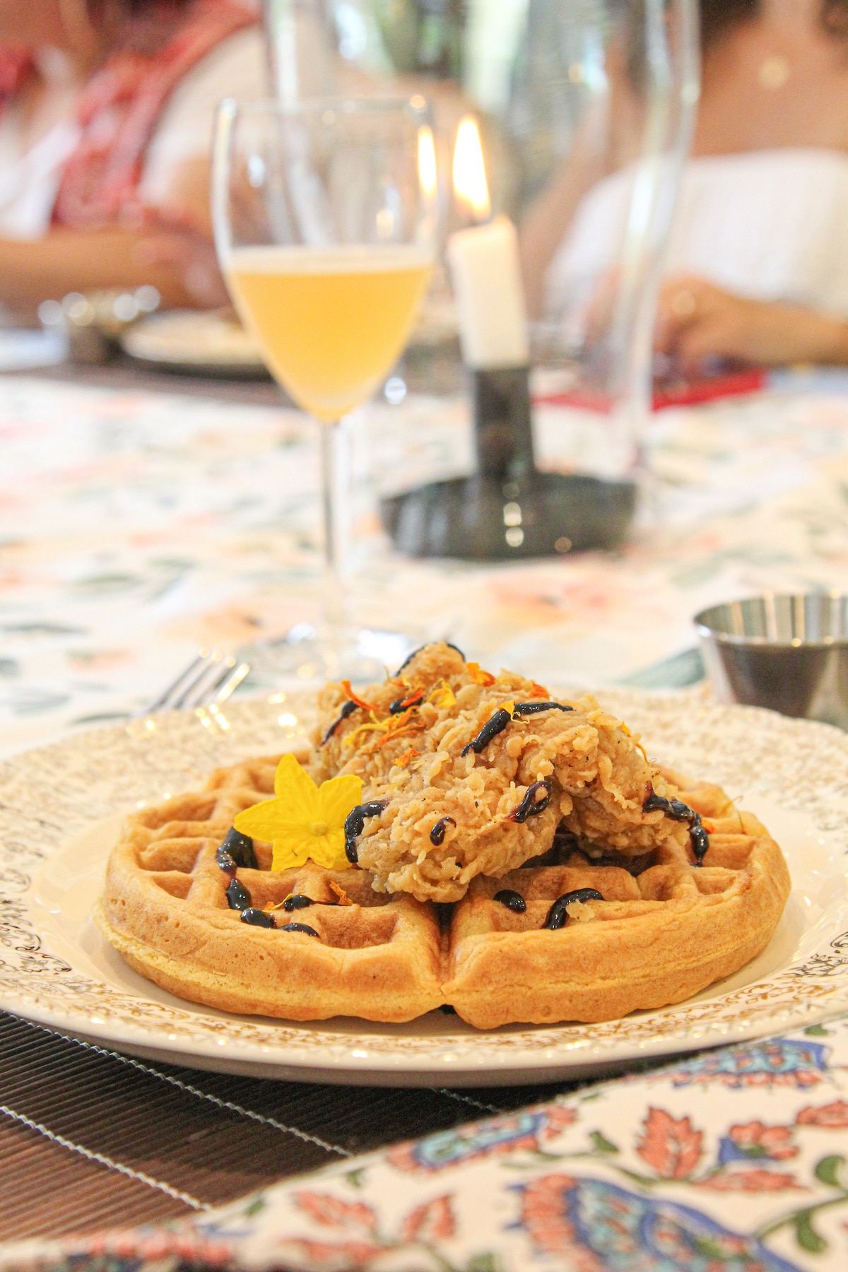 Plated chicken and waffle with champagne at Thee Wild Lux — culturally themed dinner