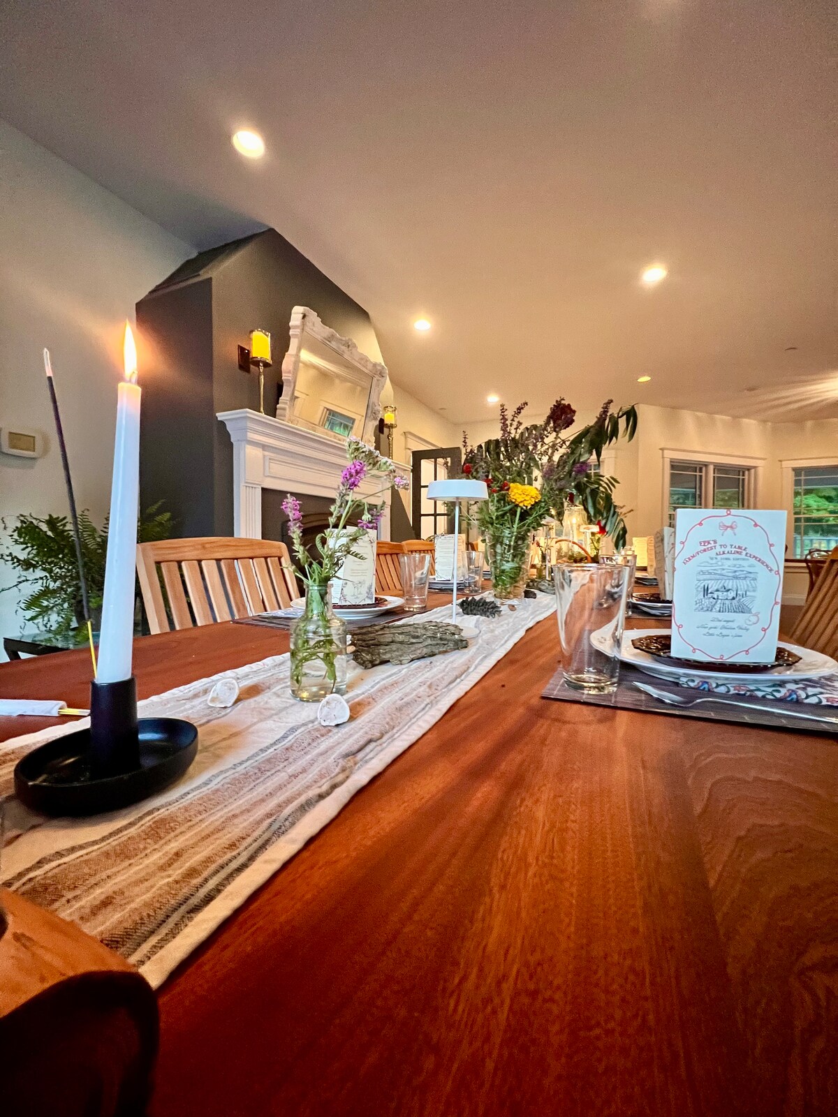 Culturally themed farm-to-table dinner at Thee Wild Lux — candlelit table, wildflower arrangements, event menus