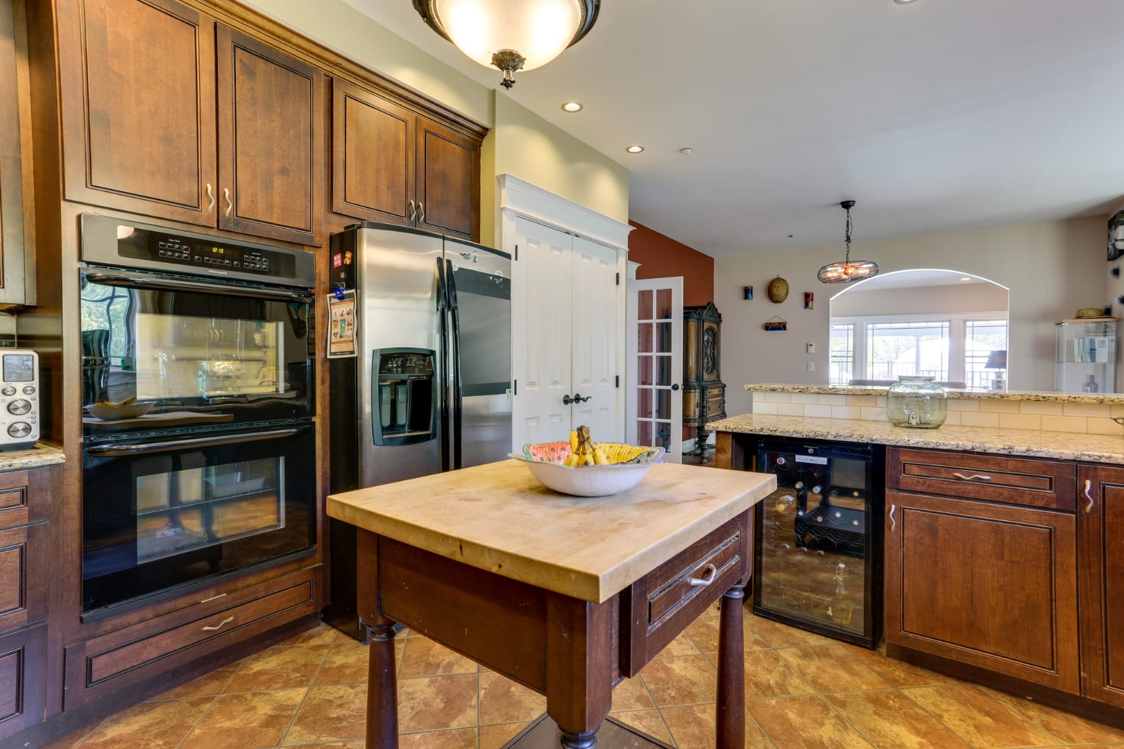 The professional kitchen at Thee Wild Lux — double wall oven, stainless appliances, butcher block island, wine fridge